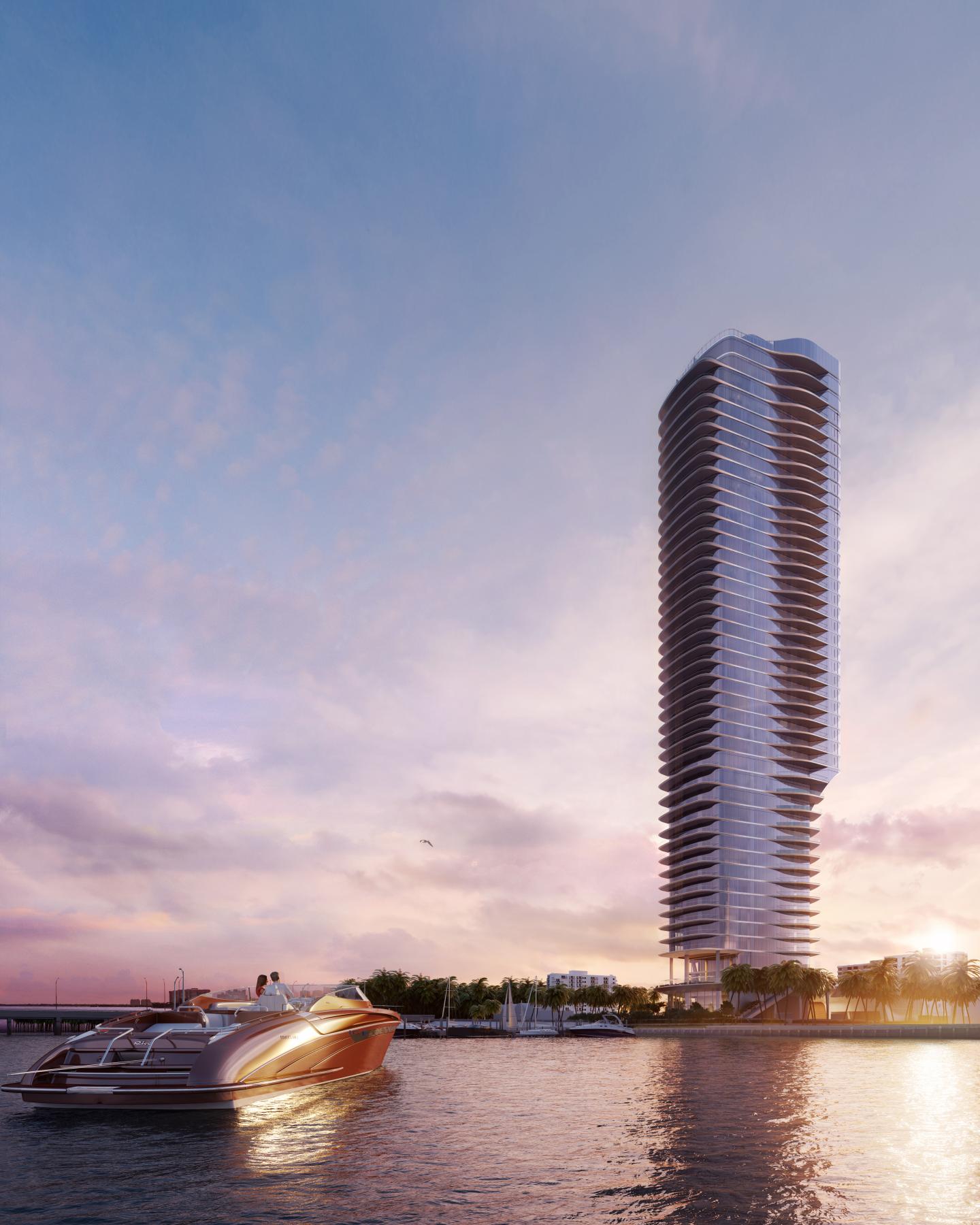 A modern high-rise tower by the water at sunset with a luxury boat in the foreground.