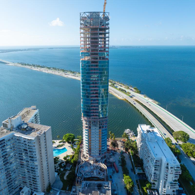 High-rise tower under construction by the waterfront.